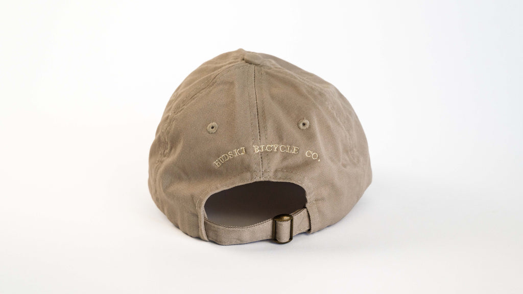 Hudski Bikes Brown cap with 'Rusty Bicycle Co.' logo on a white background